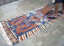 Waschen eines Tibet Teppichs mit Drachen Muster.